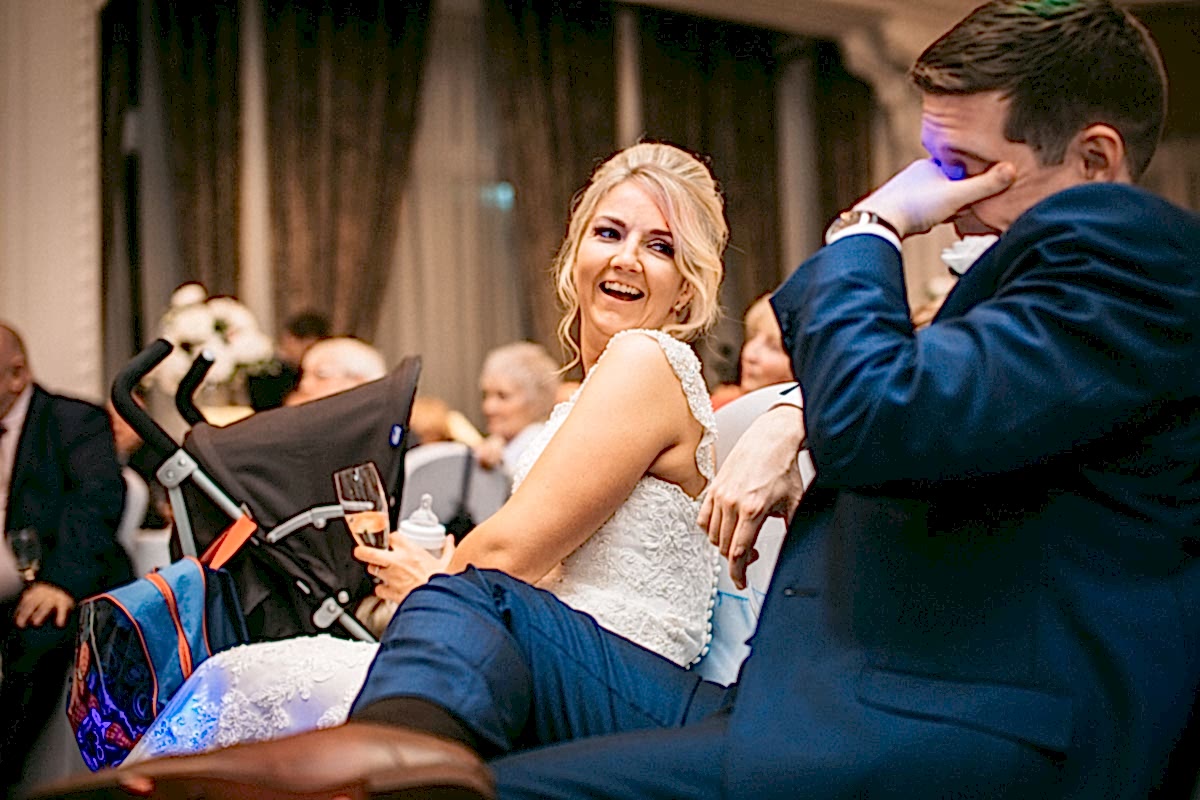 bride laughing at groom during best mans speech