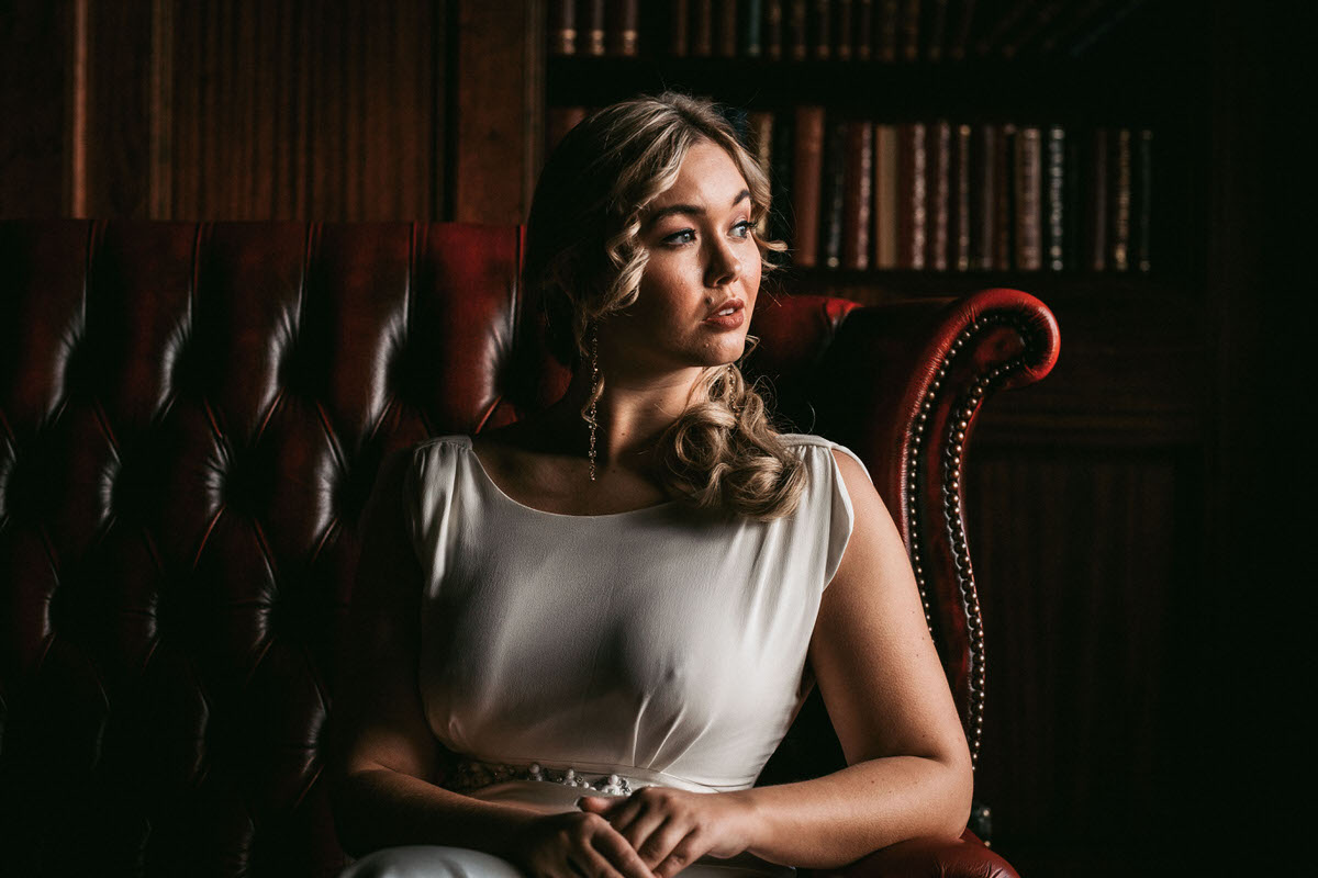 bride sits and looks out of window at ashfield house