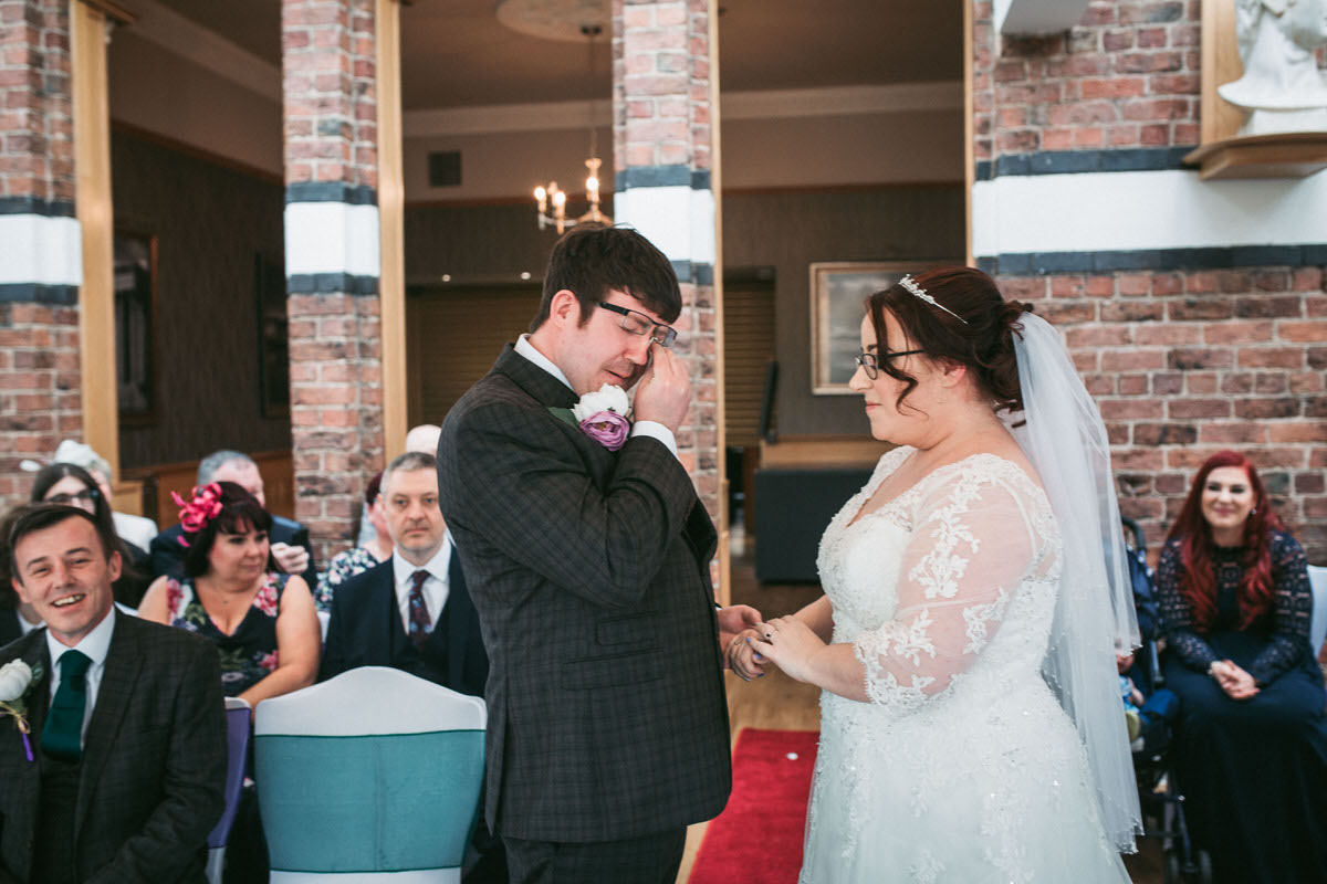 the groom wipes away a tear during the ceremony