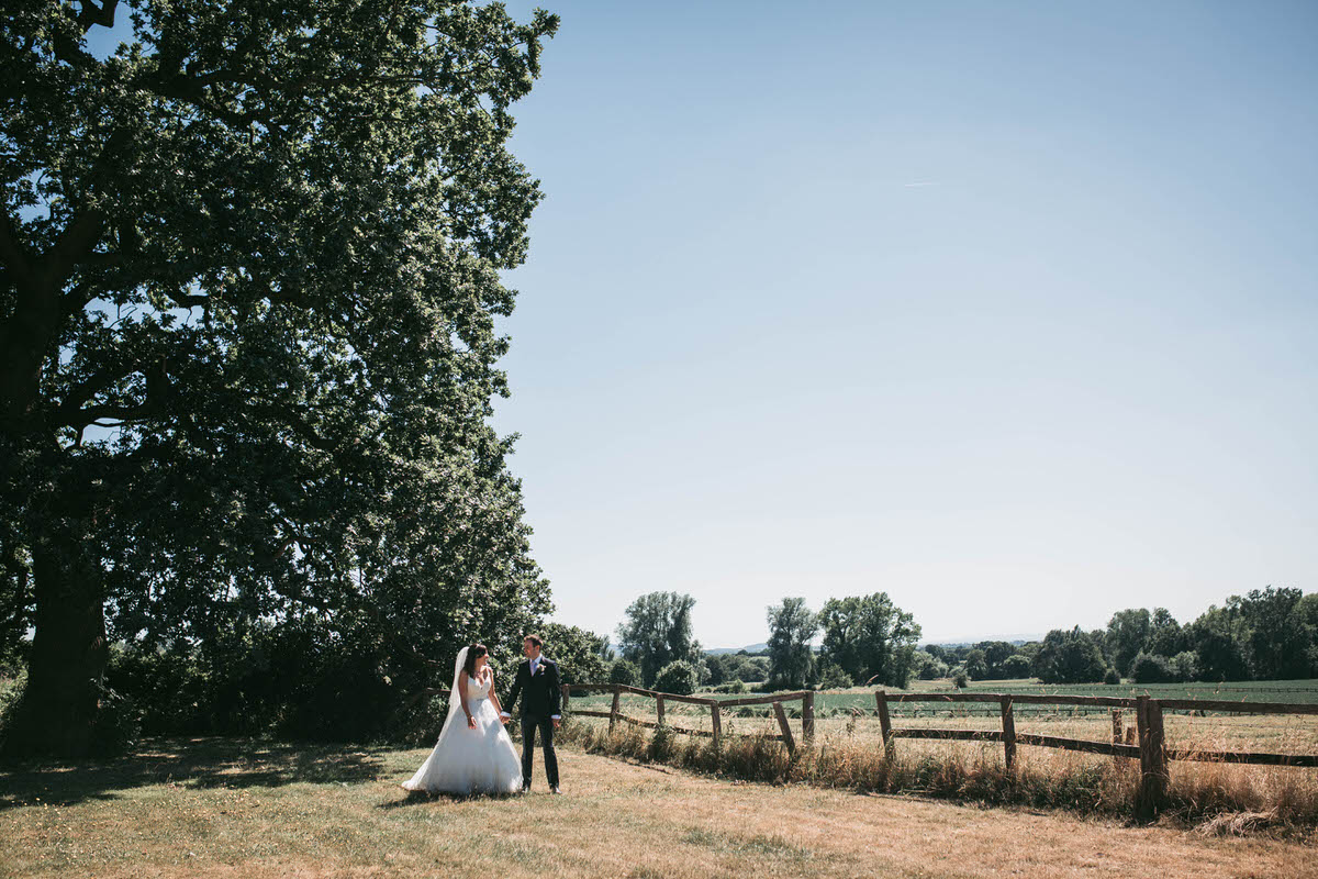 bride and groom take a stroll at willington hall in the beautiful grounds in cheshire in the lovely sunshine