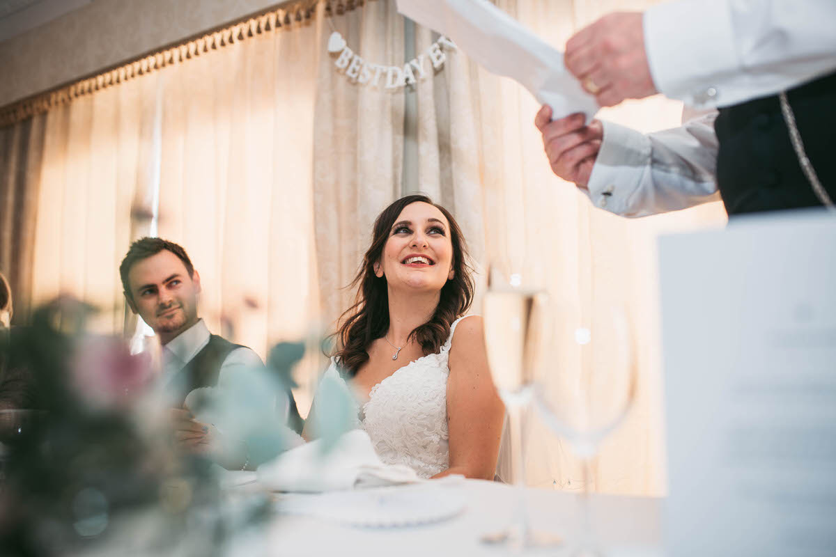 bride looks up at her dad during the speeches