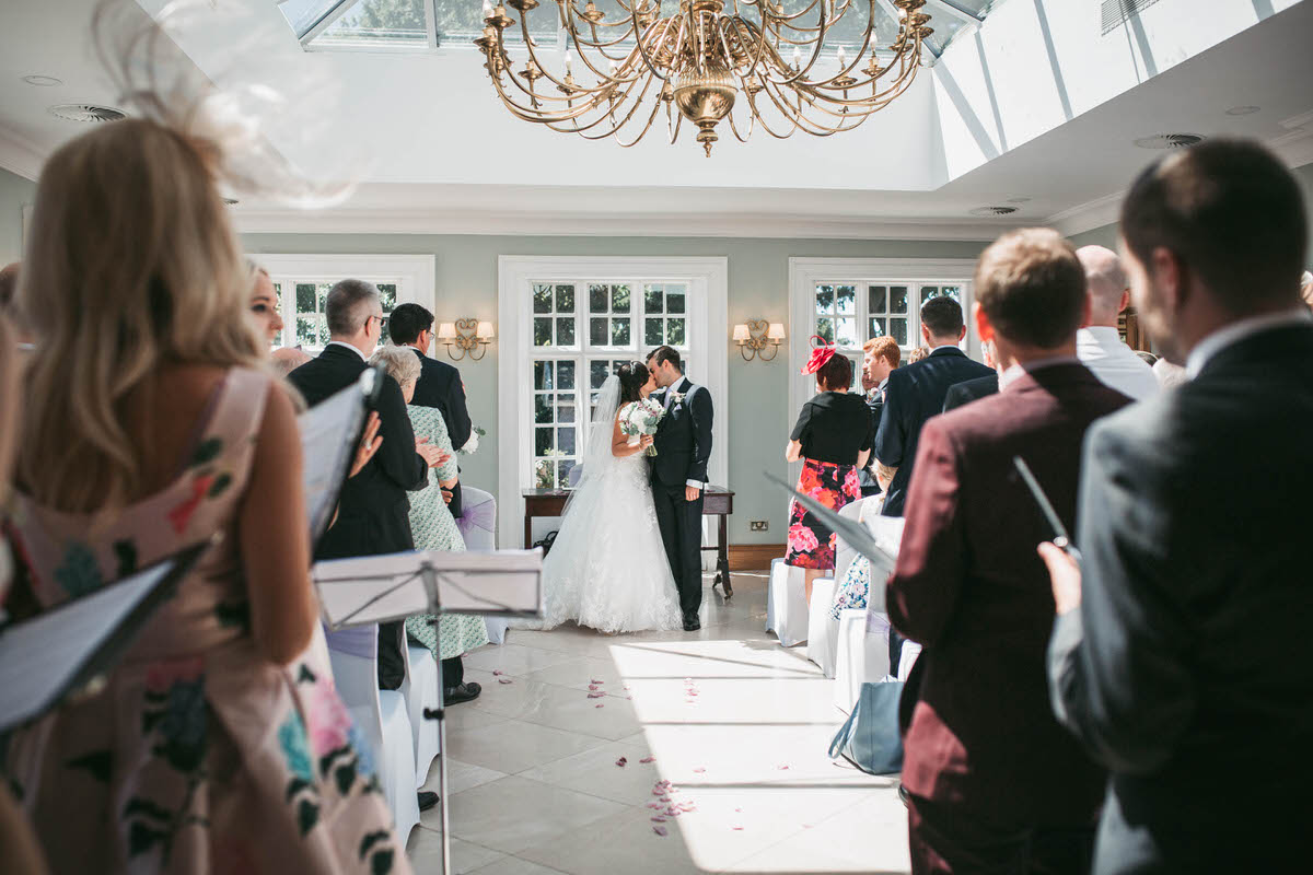 Bride and groom kiss at the end of their wedding ceremony at willington hall in cheshire