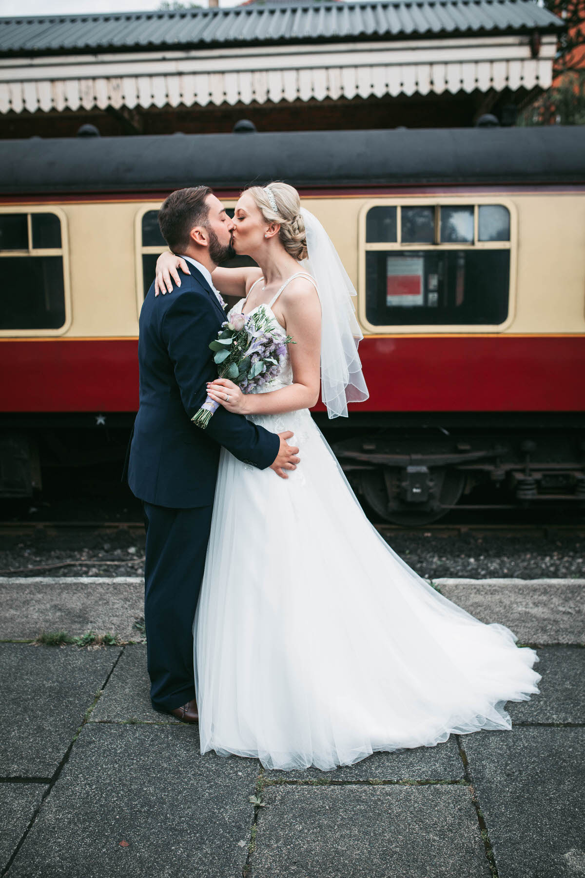 kisses in front of a train at llangollen railway station